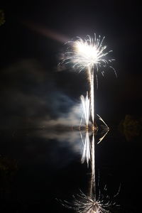 Firework display over lake at night