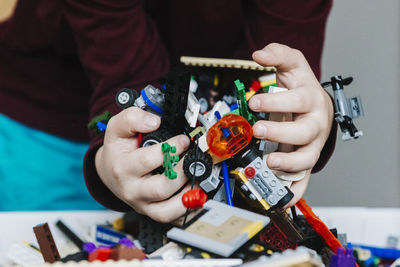 Midsection of woman working with toy on table