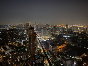 Illuminated cityscape against sky at night