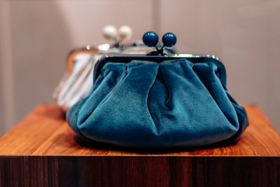 Blue and white velvet clutches on a wooden stand. fashion details, women's accessories