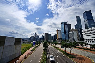 Road amidst buildings in city against sky