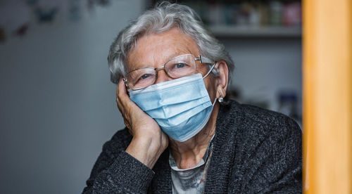 Portrait of senior woman wearing mask at home