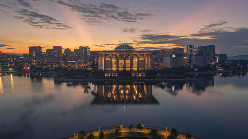 Reflection of buildings in city at sunset