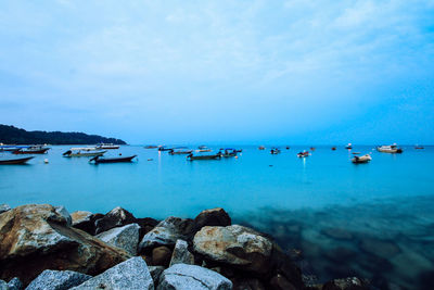 Sailboats in sea against sky