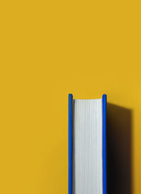 Close-up of open book on table against wall