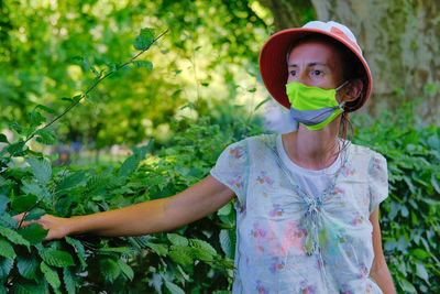 Portrait of woman standing by plants