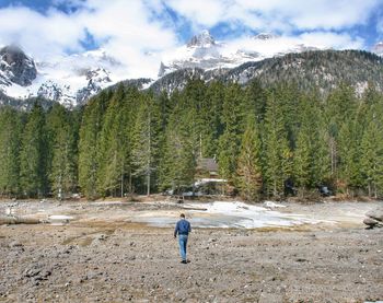 Rear view of man on snowcapped mountains against sky