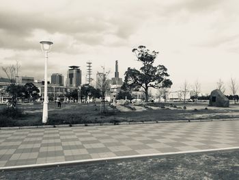 View of street and buildings against cloudy sky