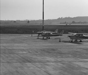 Airplane on airport runway against sky