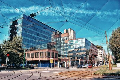 Railroad tracks by buildings in city against sky