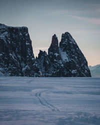 Scenic view of snow covered land against sky during sunset