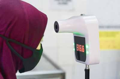 Close-up of woman in hijab checking temperature