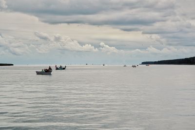 Boats sailing in sea against sky