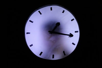 Close-up of clock over black background