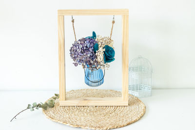 Close-up of glass vase on table against wall at home