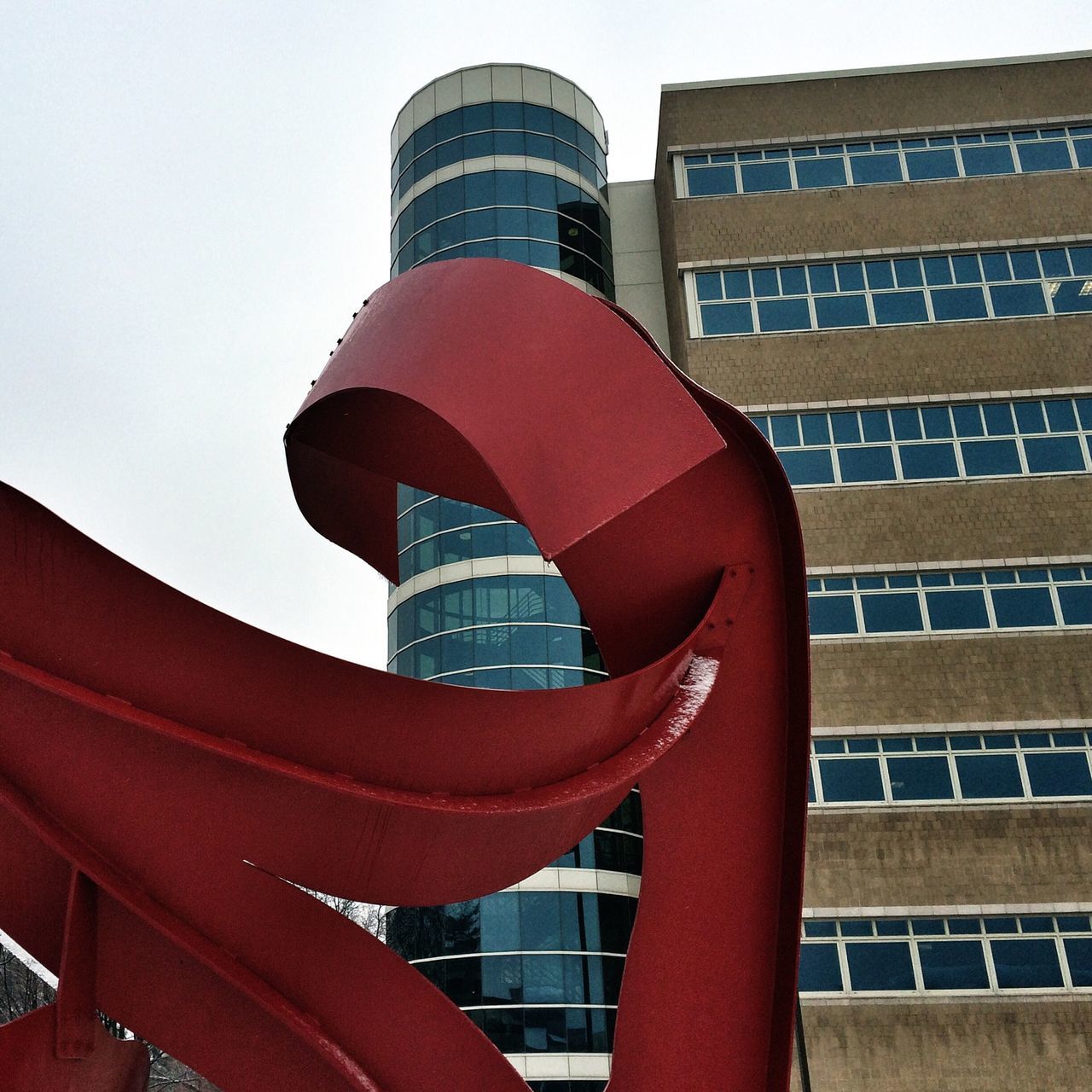 architecture, building exterior, built structure, low angle view, tower, red, city, tall - high, modern, building, office building, skyscraper, travel destinations, clear sky, day, sky, famous place, outdoors, window, capital cities