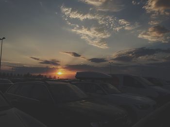 Cars on road against sky during sunset