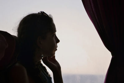 Side view of young woman against clear sky