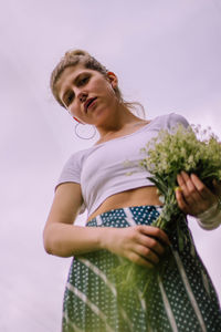 Low angle view of woman standing against sky