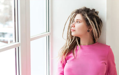 Portrait of beautiful young woman looking away at home