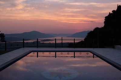 Scenic view of swimming pool against sky during sunset