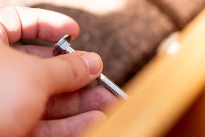 Close-up of hand holding screw