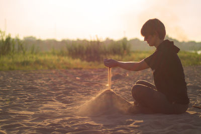 Woman spilling sand at beach