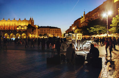 People at illuminated town square at night