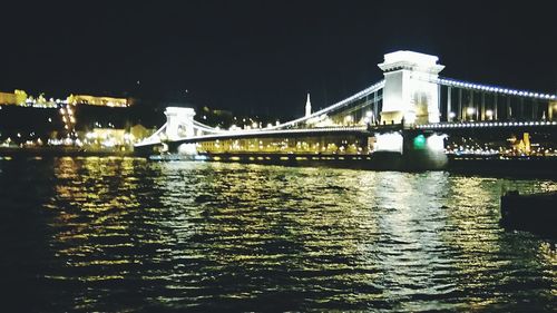 Low angle view of bridge over river at night