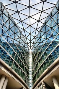 Low angle view of glass building against sky