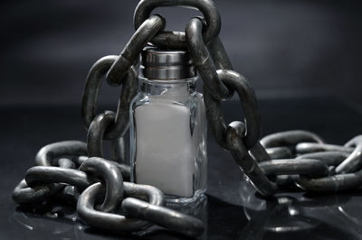 Close-up of chain with salt bottle