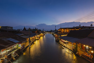 High angle view of illuminated city by river at night