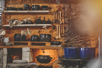 Cast iron pot with fresh herbs, spices and kitchen utensils for tasty cooking on rustic table.