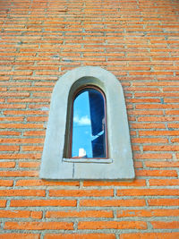 Low angle view of window on brick wall