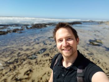 Portrait of smiling young man on beach