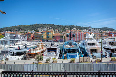 Boats in harbor against blue sky