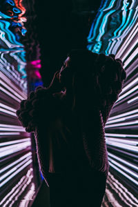 Side view of woman standing against illuminated stage