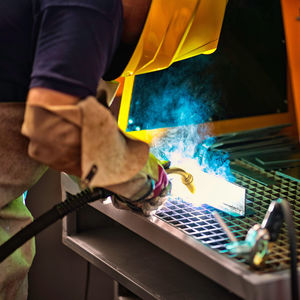 Close-up of worker welding metal at factory