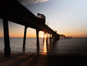 Silhouette pier on sea against sky during sunset