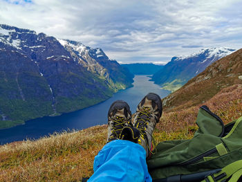 Scenic view of a hikers feets against a norwegian fjord from a mountain topp 