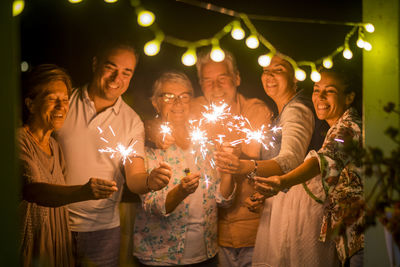 Happy family holding illuminated sparklers at home