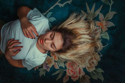 High angle view of young woman lying on bed