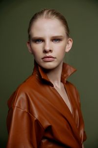 Portrait of young woman against black background