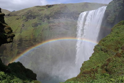 Scenic view of waterfall against sky