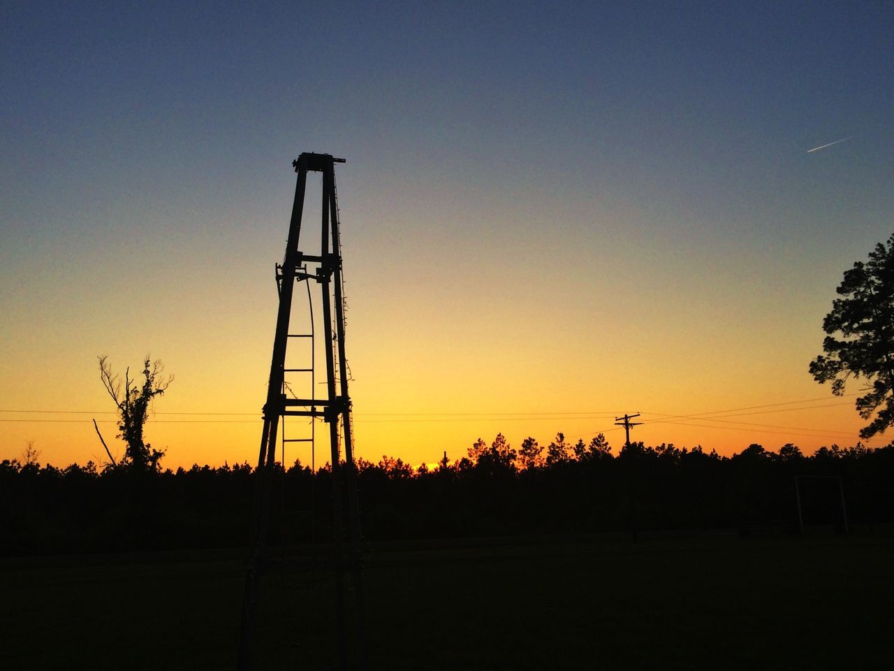 sunset, silhouette, clear sky, copy space, orange color, landscape, field, fuel and power generation, tranquility, electricity pylon, tranquil scene, nature, beauty in nature, scenics, technology, sky, dusk, electricity, tree, outdoors