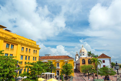 Buildings at historic colonial plaza against cloudy sky in city