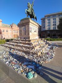 Statue of building in city against clear blue sky