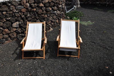 High angle view of empty deck chairs on field