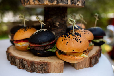 Burgers made of white and black buns with meat, vegetables, salad and sesame seeds