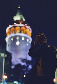 Low angle view of illuminated statue against sky at night